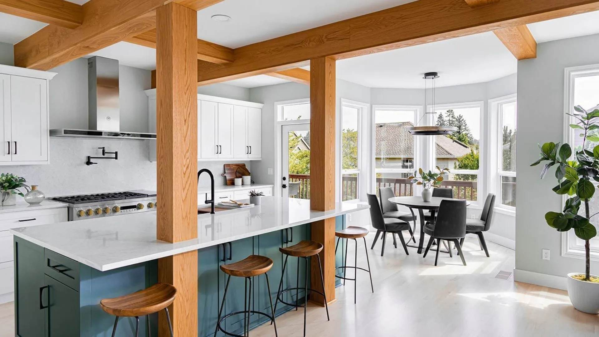 Open-concept kitchen remodel by DWV Construction with exposed Douglas fir beams, marble island and dual range