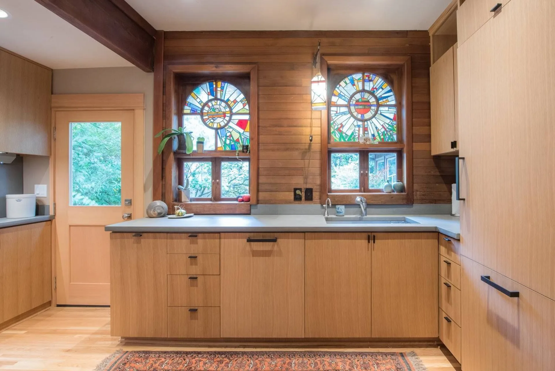Modern Portland kitchen with rift-cut wood cabinetry and stained glass windows